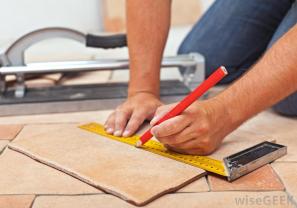 person-with-ruler-installing-tile-floor